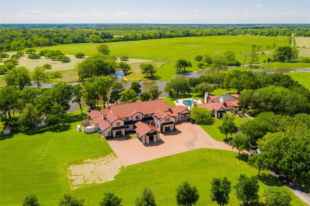 The incomparable Broad Oaks Ranch in Hempstead, includes 1,305+/- acres of 3.5 miles of Brazos River frontage with beaches, ponds, 8+ acre stocked fishing lake, 5 water wells, improved/extensive open pastures and thick woods providing natural habitat for wildlife. Aerial view shows exquisitely appointed 4 bedroom/5 full bath/6 half baths main house, pool/hot tub/water features, remodeled 3 bedroom/3 bath guesthouse, barndominium, 8 stall horse barn and so much more!