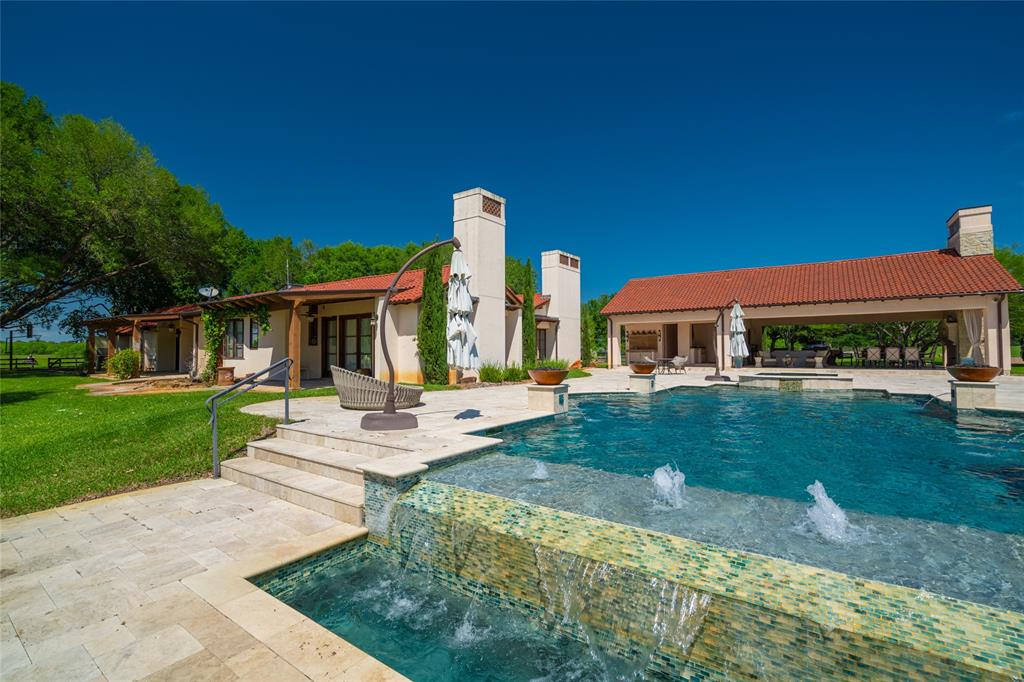 How relaxing is the infinity edge, spa, four water features and bubblers of the BACKYARD heated Pool! Seen here is the 3 bedroom Guest House with the outdoor Kitchen and Dining areas.  Not seen to the right of the covered Dining is the Main House.  Notice the numerous seating areas, both open and covered, afforded in the complex\'s carefully planned design.