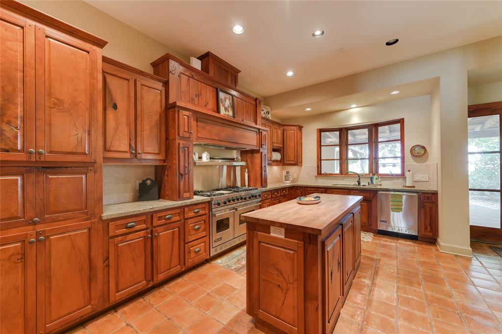 The KITCHEN (17 X 11) provides ample storage space with its stained wood cabinets/drawers with granite counters/stone backsplash.  The center island features a butcher block counter.  A wood framed bay window adds a charming coziness to the space while the stainless Viking appliances provide state of the art appliances for use by the cook!