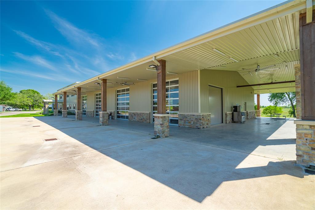 A closer view of the BARNDOMINIUM with its series of four car bays on one side of the building and two car bays on the other side.  The main entry is seen at the far end of the building.