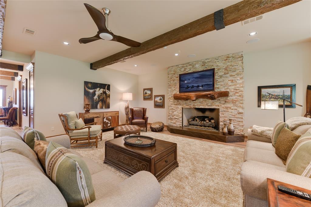 The housing portion of the Barndominium includes a spacious LIVING ROOM (38 X 25) to accommodate large groups visiting the ranch. It features hardwood flooring, 10 foot ceilings with exposed wood beams/recessed lighting/ceiling fans, picture windows with Roman shades/privacy screen overlooking backyard, gas log fireplace (wood mantle, stone surround/base)