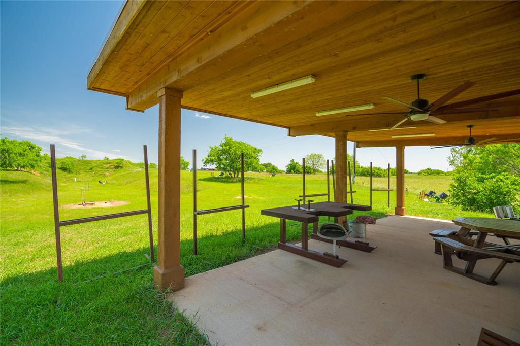 RIFLE RANGE with covered facility and hillside targets beyond.