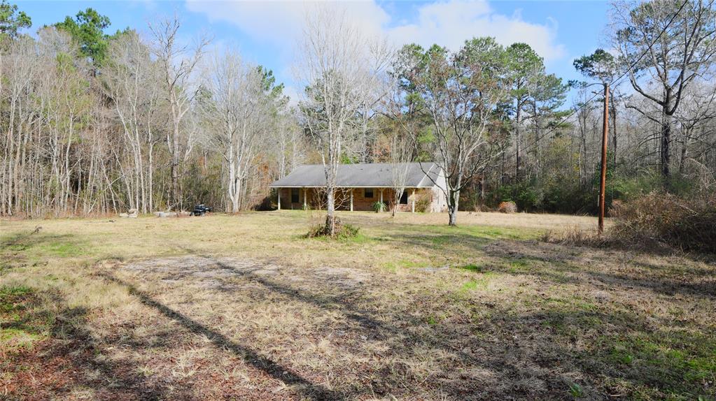If you are looking for seclusion and privacy, this is it!  This 2 bedroom, 2 bathroom home is nestled in the middle of 12+ unrestricted acres surrounded by trees.  Large living room with additional 11' x 10' sitting area that could be converted into a 3rd bedroom.  Cathedral ceilings in the living area.  Enjoy the peace and quiet from the spacious front porch.  Located within Tarkington ISD.