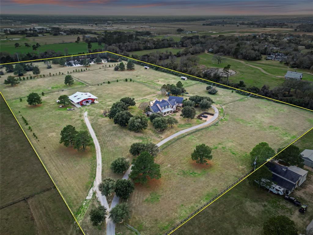 This Gorgeous Estate on 25 Acres is the Best of Both Worlds, Country Living with City Convenience! This Custom Home was Designed by Mark W. Todd Architects & Custom Built by Kerry Emmott Featuring 5 Spacious Bedrooms and 4 & a Half Bathrooms. The Relaxing Primary Suite showcases 12’ Ceilings, Large Windows, Exercise Room, Wrap Around Walk In Closet w/ Built Ins & Drawers. The Kitchen is a Chefs Dream with Top of the Line SS Appliances & a Large Center Island. From the Covered Back Porch, enjoy the view of the Resort Style Pool & Amenities. Just past the Pool you will find the 6 Stall Barn w/ Hot & Cold Water, Automatic Waterers in Each Stall, Rubber Mats, Insulated Tack / Feed Rooms & Tons of Storage Space. At the Back of the Property is the LARGE Private, Aerated Pond Stocked with Florida Hybrid Large Mouth Bass, Blue Gill, and Red Ear for fishing. Fully Fenced & Cross-Fenced w/ Electronic Entry Gate Access. 2 Wells, 2 Propane Tanks & 1 Septic! 24 Acres are Ag-Exempt w/ Low Taxes!