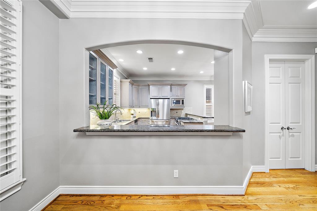 Enjoy quick meals in the spacious breakfast bar showcasing granite countertops, an arched opening, and space for additional seating.