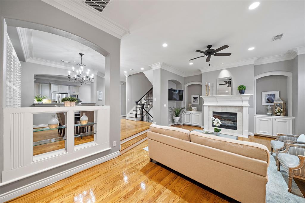 Giving the room a luxurious look, the photo showcases raised ceilings with beautiful crown molding throughout. Find recessed spaces that can easily fit an entertainment center or home decor.