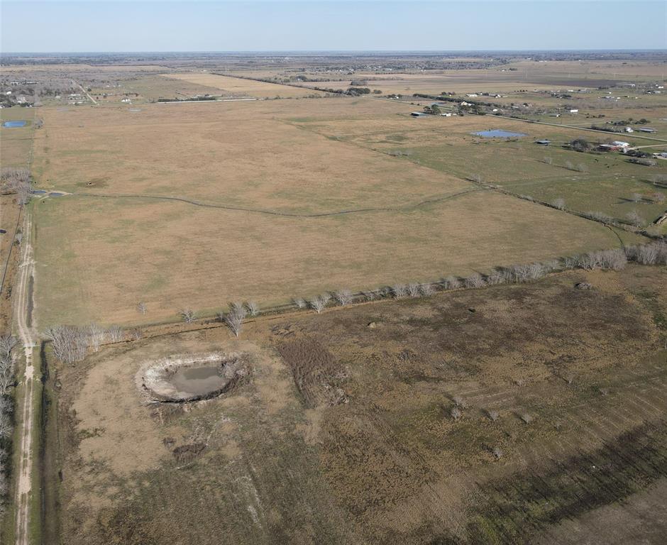 Unrestricted 80 +/-  acres of raw land in the Country to develop how you wish.  Needville ISD!!!  This 80 acres in Guy near the growing town of Needville is set back off the main road with a 60 ft wide owned access road.  Private and secluded with very few neighbors you will have ample room to do as you wish.   Keep it all for yourself or develop into acreage tracts the choice is up to you!.. The acreage has cross drainage and perimeter drainage surrounding the property.  Previously a high producing hay meadow, it can be developed and groomed into an income producing Ag exempt property.  The acreage is perimeter fenced and currently grazes cattle and is perfect for raising cattle, horses, or whatever ag project you desire.