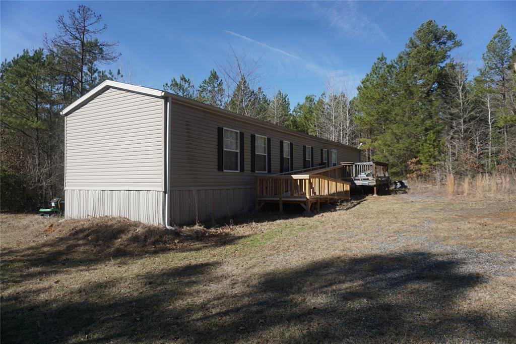 Remarks: 2015 model single wide in excellent condition very secluded sitting on 91 acres of wooded property. There is an additional septic system to the small cabin that is in front of the main house with water ran to it. The property over all is 100% wooded with mostly pine but there is a mix of hardwood throughout. Timber exemption is in place. There is a pond with a pier but it will need some work and lots of rain to fill it back up. Lots of deer and hogs and extra seclusion for the most private person to enjoy. The main entrance is used and maintained by the oil field company to access a gas well at the back of the property.