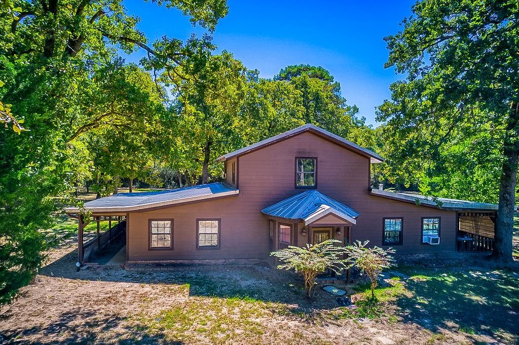 Private country living is what you will find with this one owner, partially log sided 3BD/2BA home on 10.3 acres in Buffalo ISD! Property is located just outside of Oakwood city limits and features a unique floor plan with a step down den area w/propane fireplace, formal dining and two large upstairs rooms. Kitchen has tons of cabinets and nice counter space. Living room has a wood burning stove and a back exit to the expansive covered patio! Some cement flooring and carpet throughout! Detached laundry room/utility room! The double detached garage is nicely planned out with double doors, double carport parking and an upstairs loft room, shower and additional bedroom for guests. Perfect home to enjoy the outdoors!