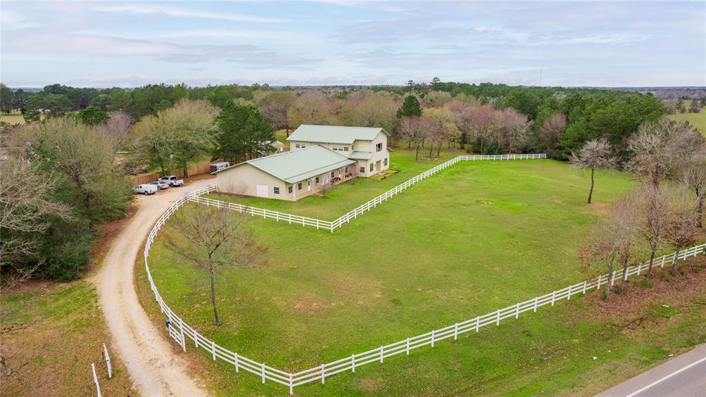 ONE OF A KIND OPPORTUNITY! This UNRESTRICTED property has over 6 acres and 700 ft of frontage on FM 149! This is a wonderfully flexible piece of property that could be for personal use, business use, horses, or a mixture of all combined. There is a GORGEOUS BARNDOMINIUM with intricate wood work built with the highest of quality, great views, and open living space plus a loft. You'll love the warm feel of this home! Downstairs, you have office spaces and lots of storage or workshop space that can be utilized in a variety of ways - current usage includes a workout area, conference room, and more. Outside, you have a 20x36 hydroponic greenhouse and additional garden beds to grow LOTS of produce. For the horse lover there is a barn with 2 stalls, hay storage, and a covered working area, plus an area 120x50 designed for a riding area! In addition, there are TWO additional 2000 sf insulated workshop areas and infrastructure to add MORE! Run your business, rent it out, or enjoy it personally!