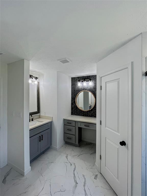 Separated double sinks; this one with its own vanity area near one of the walk-in closets