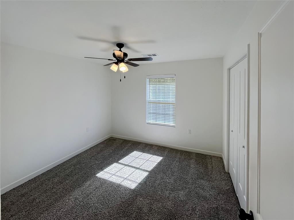 Secondary bedroom with carpet and ceiling fan