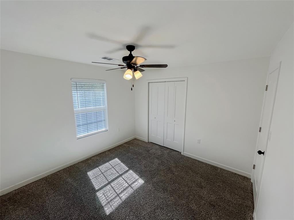 Third bedroom with carpet and ceiling fan