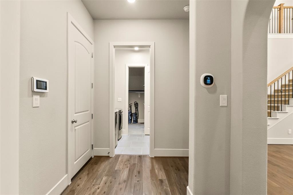looking out from the powder bath, through the utility room and into one of two primary closets.This would make and excellent mud room to transition into the home.