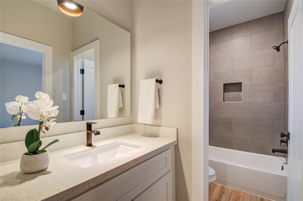 Primary bath with dual vanities with by Design Contemporary Cabinets, Quartz countertopsand MOEN Fixtures