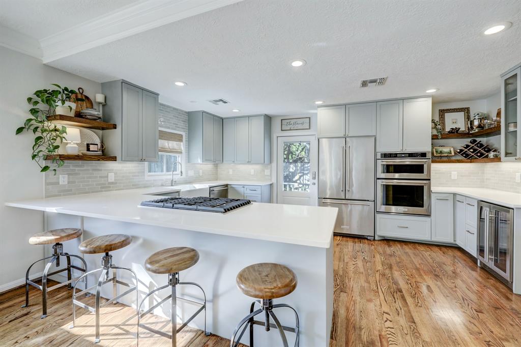 In addition to a formal dining table the kitchen includes a long breakfast bar.  Counter space to the right is ideal for a coffee and beverage station.