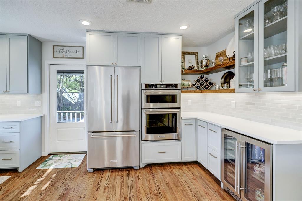 The stainless appliances, glass front cabinets and beautiful open shelving cap off a perfectly designed kitchen.