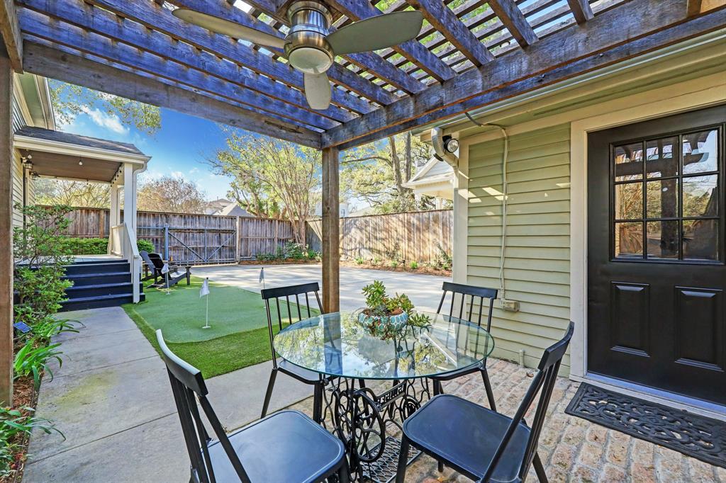 Venture outside via the kitchen door and covered back porch and you'll find the patio with a pergola and ceiling fan, the perfect spot for breakfast, cocktails or an outdoor dinner.