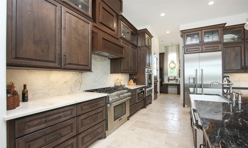 This kitchen is as functional as it is beautiful with glass fronted cabinets and gorgeous counters and backsplashes.