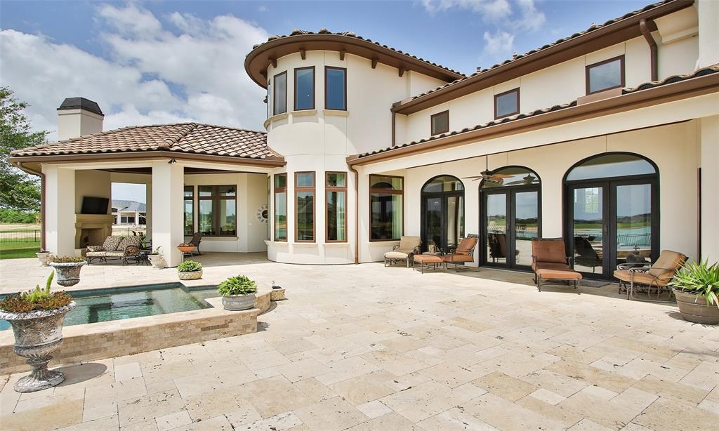 The back of the home is as stunning as the front!  Expansive travertine patio area with so much space to place  multiple sitting/eating areas or furniture of your liking.