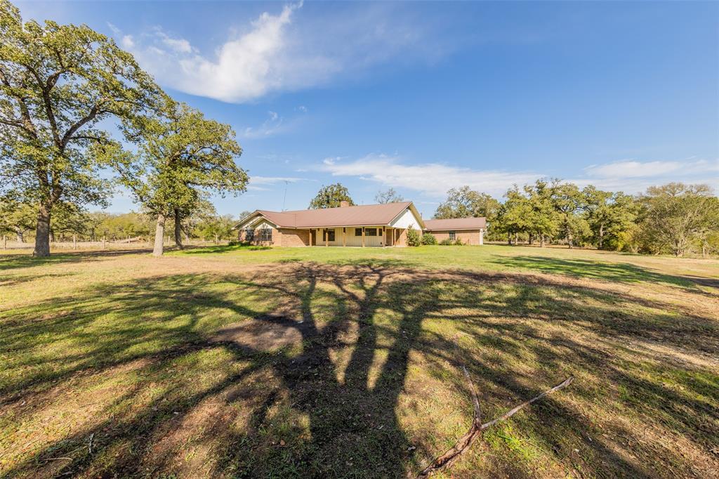 Nestled on 50.5 gorgeous acres, this 2,764 square foot brick home with a metal roof is located behind a cluster of beautiful trees. The property is found on a pleasant County Road in Lincoln, Texas. Step inside the 4 BD / 3.5 BTH home that has character and hard to find features with a price that gives you room in the budget to customize the cosmetics to make the place your own. You'll enjoy picturesque views of natural waters and the woodlands. The generous acreage provides plenty of room for enjoyment. Representing the welcoming personality of the home, a front-facing, breezy porch is a nice spot for relaxing with refreshments, perhaps while hosting friends. It's a great idea to make a competitive offer on this one
