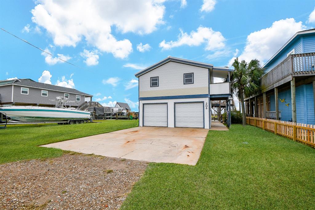 Many folks say that wherever there is water, there is peace! This unique home, right on the water, is a fisherman and water lover's dream! The 2-story, single family home is located at 206 Pompano Beach Lane, Surfside, TX, in the delightfully nautical Surfside Shores community. (Pictured here are the attached garages, atop a doubel wide driveway.