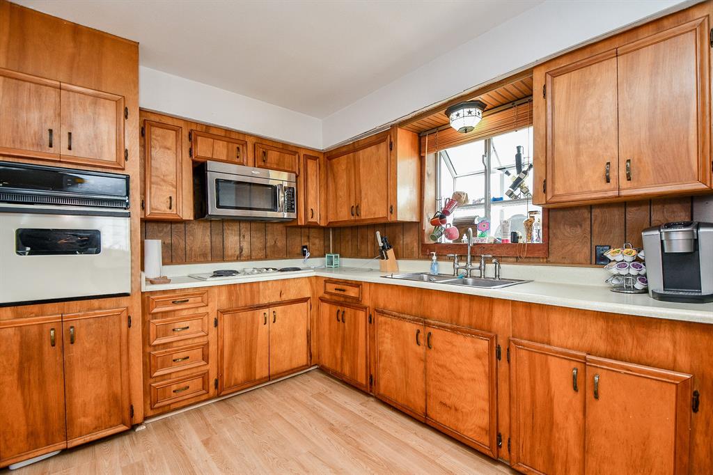 The wood paneled backsplash just ices the cake in this inviting kitchen, with stainless steel appliances adding to the glow!