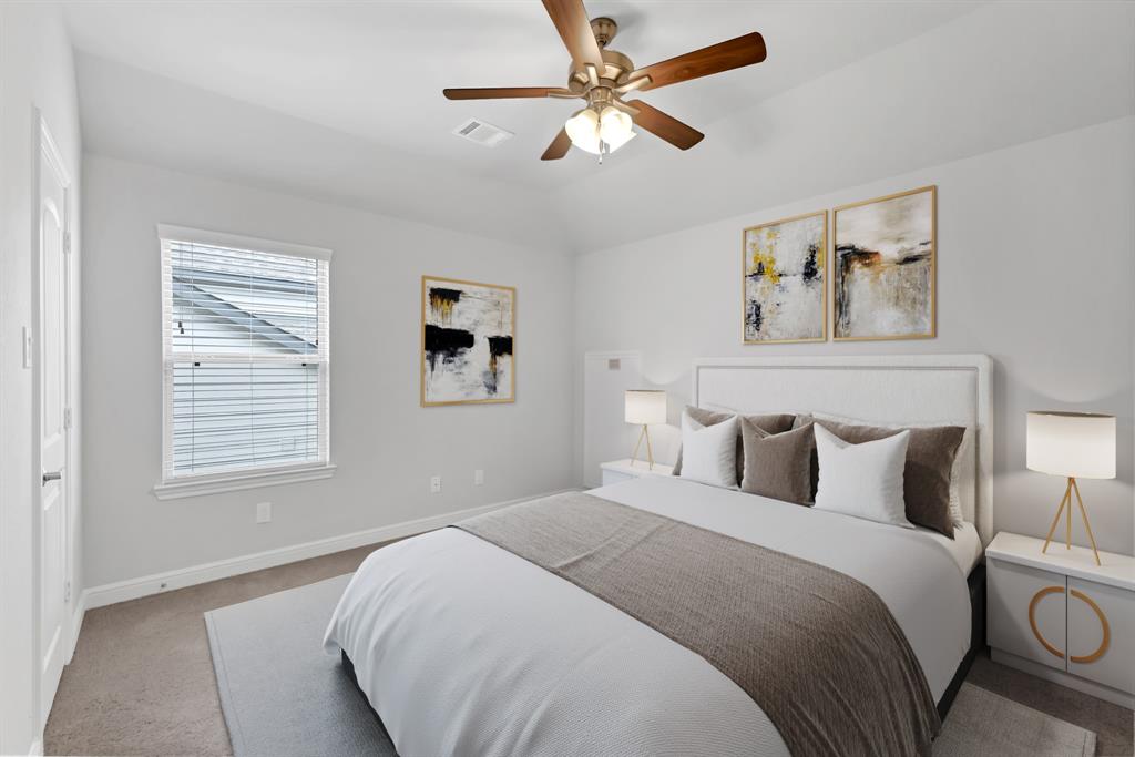 Secondary bedroom features plush carpet, custom paint, dark stained ceiling fan with lighting, large window with privacy blinds and access to the Jack and Jill bath.