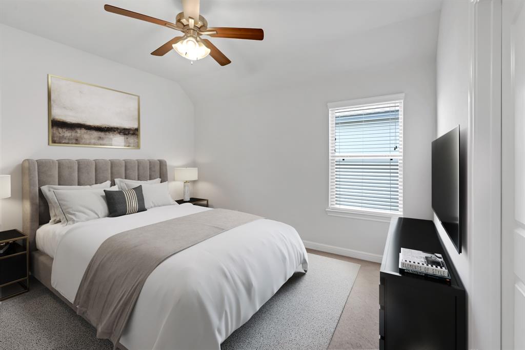 Secondary bedroom features plush carpet, custom paint, dark stained ceiling fan with lighting and a large window with privacy blinds.