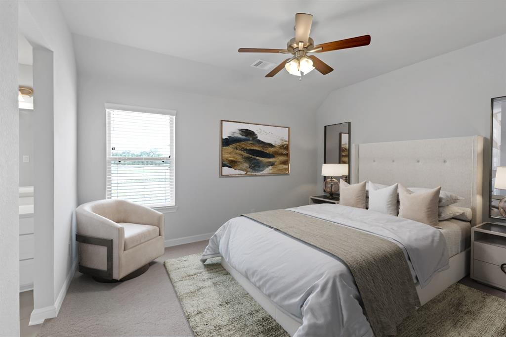 Secondary bedroom features plush carpet, custom paint, dark stained ceiling fan with lighting and a large window with privacy blinds.