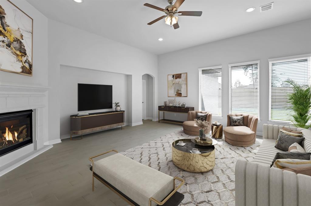 Gather the family and guests together in your lovely living room! Featuring high ceilings, recessed lighting, dark stained ceiling fan, custom paint, gorgeous floors, fireplace with mantel and large windows that provide plenty of natural lighting throughout the day.