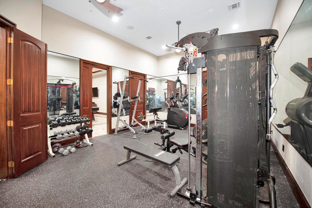 The gym is located by the gameroom and garage. Includes a large closet for storage. There is lots of built in storage and has its own sink.