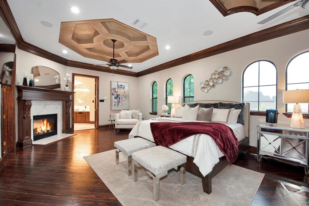 This primary bedroom features soaring high ceilings, private access to a balcony overlooking the 2 acre estate and a fireplace.