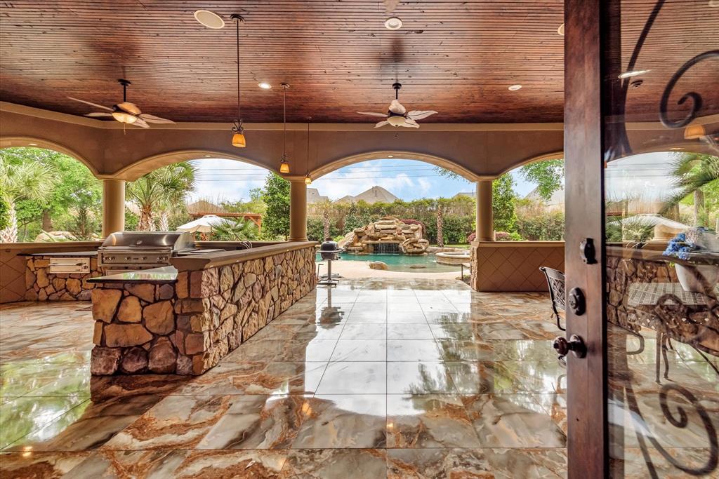 When you walk out your back door, it leads you to your outdoor entertainment area featuring a large outdoor kitchen perfect for entertaining guests, bar and dining area. This outdoor living space over looks your beautiful swimming pool, grotto and lazy river.