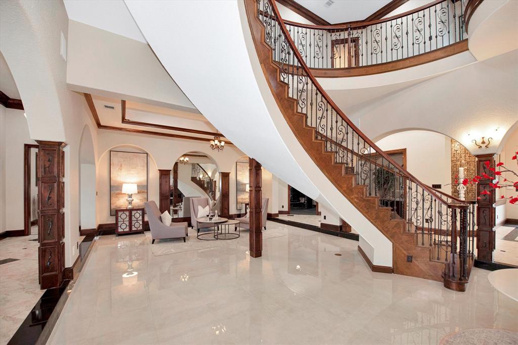 To the right of the grand entry, there is a sitting area nestled under the stairs with beautiful views of the 2 acre estate and swimming pool.