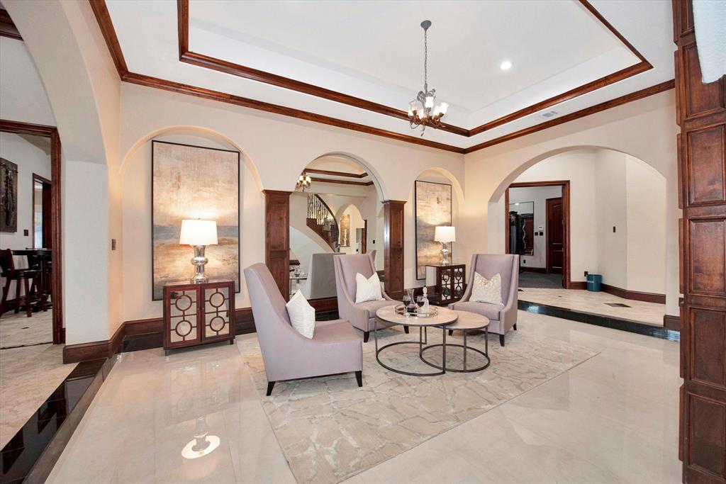 To the right of the grand entry, there is a sitting area nestled under the stairs with beautiful views of the 2 acre estate and swimming pool.