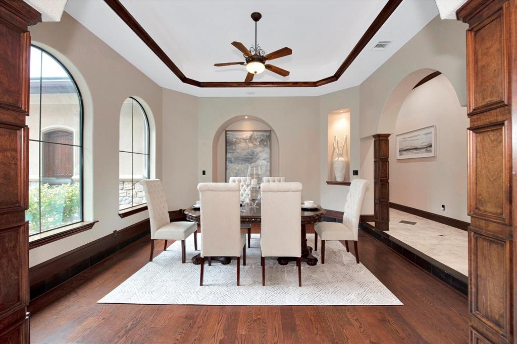 Formal dining room with large windows with tons of natural light and views of the front of the estate.