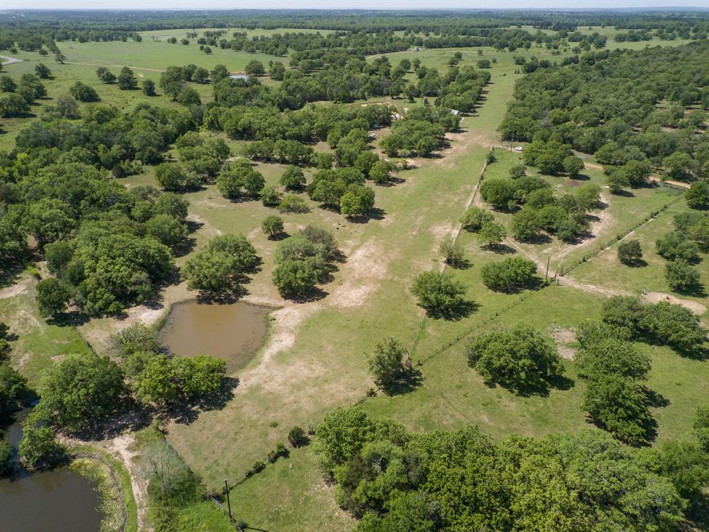 317 Lois Lane Paige, Texas Make a time to see this beautiful 21.557 acre tract in Bastrop County located near Hwy 290 and Hwy 21 East. It is scattered with oak, cedar and pine trees and also includes 3 stock ponds and a grass airstrip. The airstrip is SW to NE and provides 1400’ of landing space while the 2496 sq ft hangar provides plenty of space to park your small aircraft. The combined tracts include an electric pole, water well and septic system. There is also access to public water! The one larger stock pond and two smaller ones along with perimeter fencing provide a perfect setup for livestock and an ideal place to build the home you have been dreaming of.