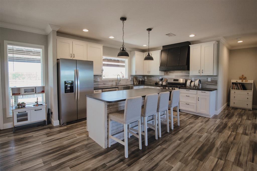 The blue “Lake House” boasts a stylish kitchen with stainless steel appliances, farmers sink, large island and great lighting. This 3 bedroom, 2.5 bath house overlooks the lake.