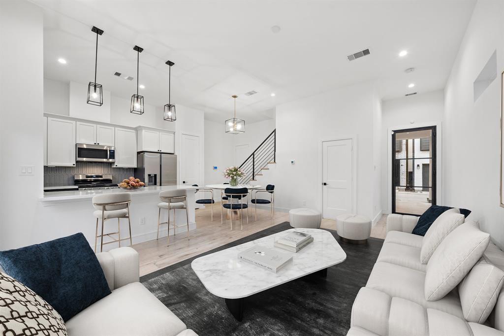 Host memorable gatherings in the stunning living area featuring an open layout to make entertaining a breeze, complemented by soaring ceilings and recessed lighting fixtures.