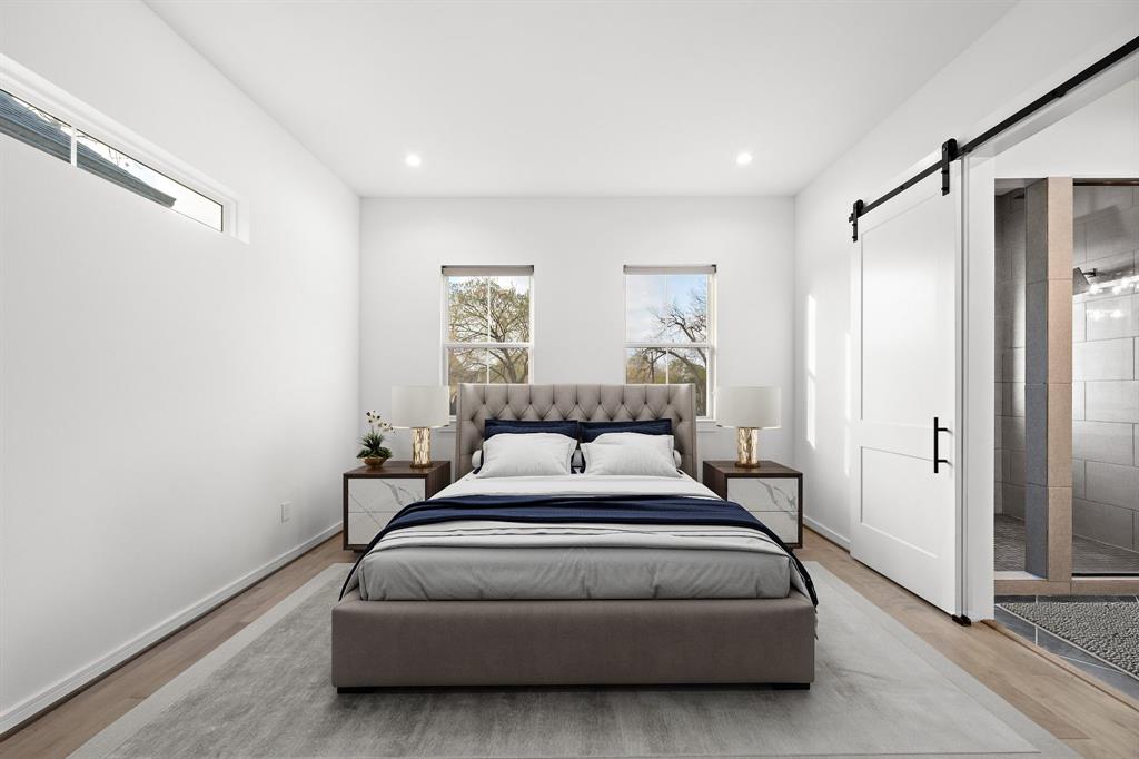 Highlighting a restful ambiance, this primary suite features upgraded engineered hardwood floors and single-hung windows with stunning neighborhood views. A sliding door opens to the ensuite bath, offering a refreshing space within reach.