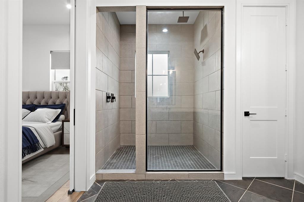 Soak in the refreshing comfort of the ensuite bath's shower, fitted with mosaic tile flooring, custom walls, and a semi-frameless, transparent tempered glass door. A water closet is also available for added comfort and convenience.