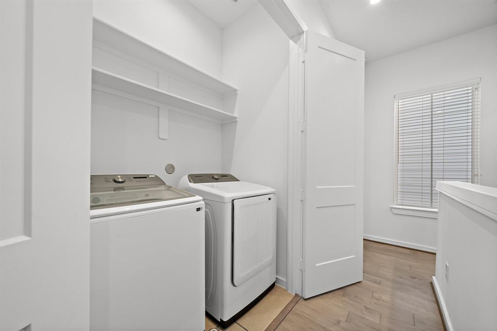 Located on the second floor, this spacious utility room is equipped with built-in shelves, a Samsung washer and dryer, and plenty of room for storage.