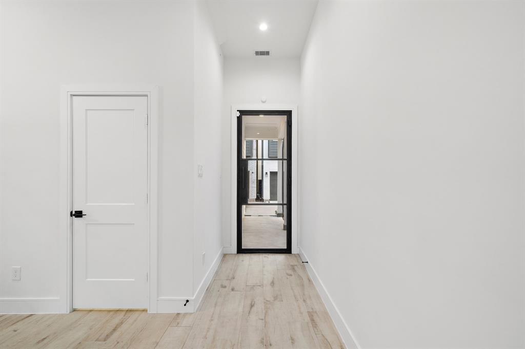 A glass door at the entrance of the home ushers you into the living area, with a conveniently located half bath accessible from the kitchen and living areas.