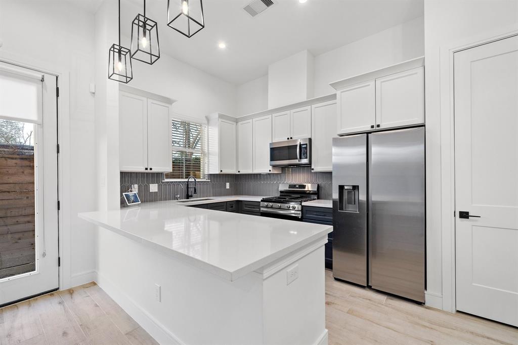 Prepare delicious meals while easily entertaining guests in the kitchen, fitted with expansive quartz countertops, stainless steel appliances, and plenty of built-in cabinets to keep the area clutter-free.
