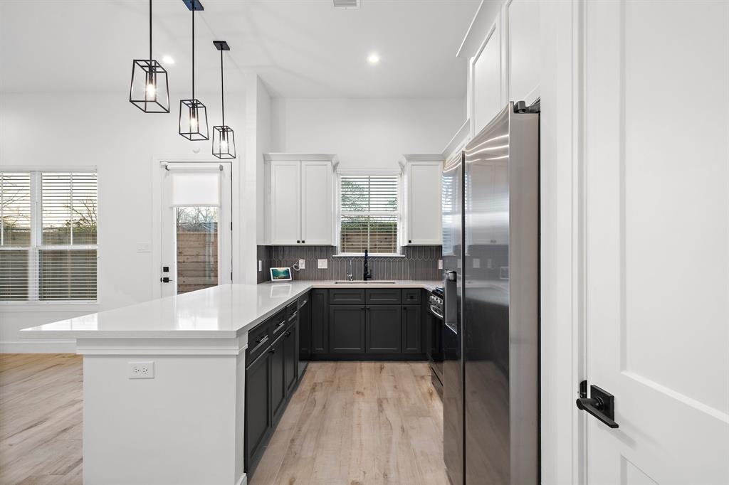 The kitchen's quartz island doubles as a breakfast bar for serving drinks and meals. Find multiple built-in drawers and cabinetry, thoughtfully designed for easy storage of pots, pans, and kitchen essentials.