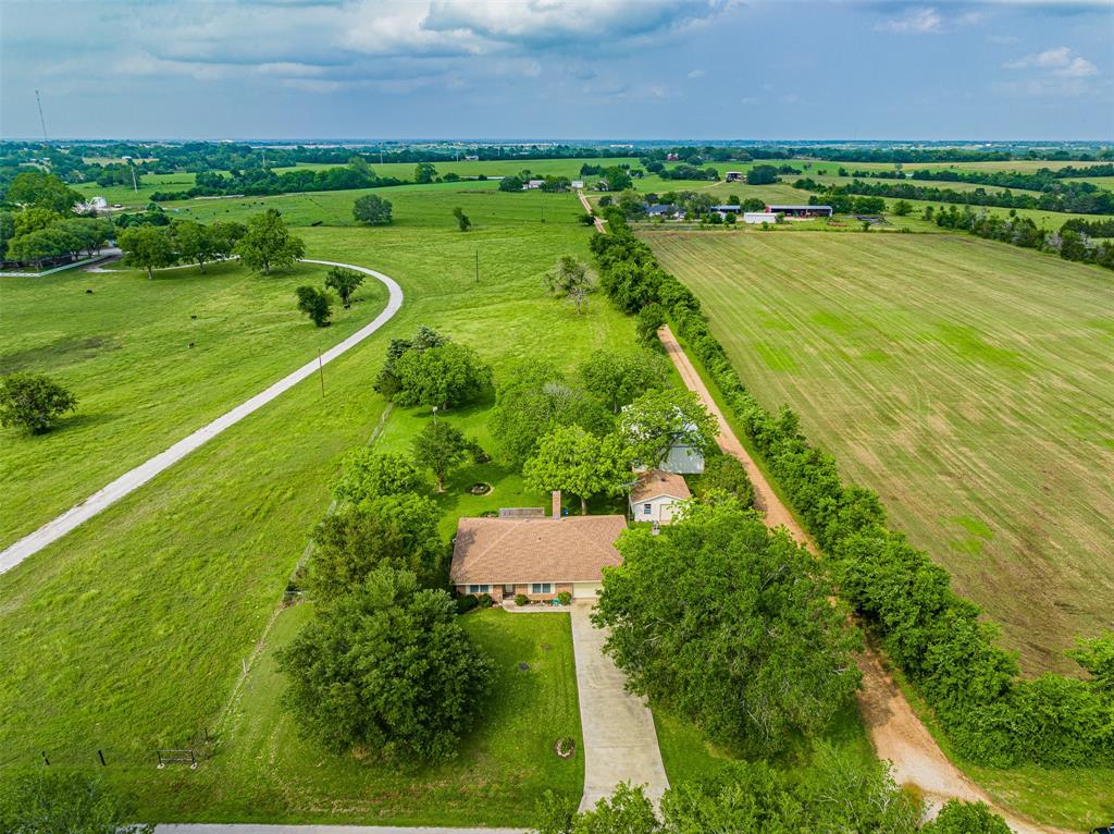 Hard to find unrestricted 1 acre with well-maintained 1-story brick home in a great location surrounded by large properties and close to town! The property also includes a 30'x50' barn, shop building, pecan and fruit trees, 2 water wells (1 with water softener) and well house and is fully fenced.
Step up to the front porch and enter the foyer open to the Dining Room with built-in buffet, Living Room with built-ins & fireplace, Kitchen with built-in breakfast table and granite counter tops. The Primary Bedroom and Bathroom are located at the back of the house and boasts a marble walk-in shower. Cut through the kitchen to the finished 2 car garage with washer/dryer.
30'x50' BARN (built in 1997) with 12' sliding doors front and back for RV parking.
SHOP building on slab with built-ins and door to park car.

Refrigerator, washer and dryer included.