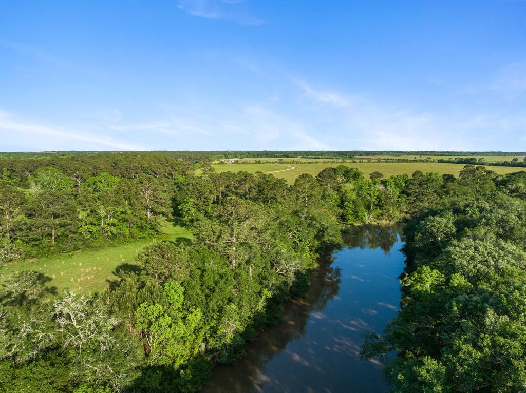 Located in a serene setting, 9 Treasures Ranch, presents the ultimate destination for any outdoorsman. Within an hour's drive from Houston, the property boasts 6,000 feet of the West Fork of Double Bayou, a navigable bayou leading directly to Trinity Bay. The cross-fenced estate comprises of 3 homes that offer waterfront views. With 600 feet of bulkhead, a dock, and boat ramp, the property is a dream for boating and fishing enthusiasts. A year-round creek that runs through the property provides water for livestock and wildlife. The property features pastures that provide grazing or hay production, as well as wooded areas for coverage. The retreat is a haven for hunting and fishing aficionados, with an abundance of game and fish. The ranch's capacity to accommodate multiple families makes it an idyllic family retreat or a hunting & fishing camp. The nearly mile-long driveway adds to the estate's exclusivity and provides a grand entrance that sets the stage for a spectacular adventure.