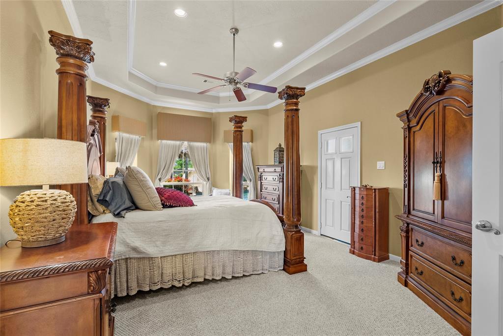 Beautiful primary bedroom with tray ceilings and inset lighting.