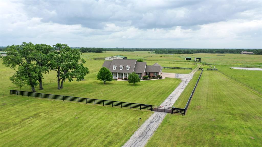 Your country estate in Madison County awaits! This beautiful custom home on 27.96 acres was well thought out and has all the bells and whistles one would want in their forever home. This 3 bedroom, 2.5 bath brick home has 3,000 sq ft of living space. If you like big rooms, you will love the large kitchen, living room, primary bedroom with an extra room attached, and primary bath with awesome his and her walk-in closets!  There is plenty of room to host gatherings inside the sunroom or out on the patio/outdoor kitchen whatever the weather permits. Behind the house, there is a 2,200 sq ft shop, a 20x60 shed, 2 loafing sheds, a 2,000 sq ft hay barn, a covered RV shed and an underground storm cellar. The property is fenced and cross-fenced and has cattle sorting pens next to the barn. This property has it all! Call The Wells Team to schedule your showing today!